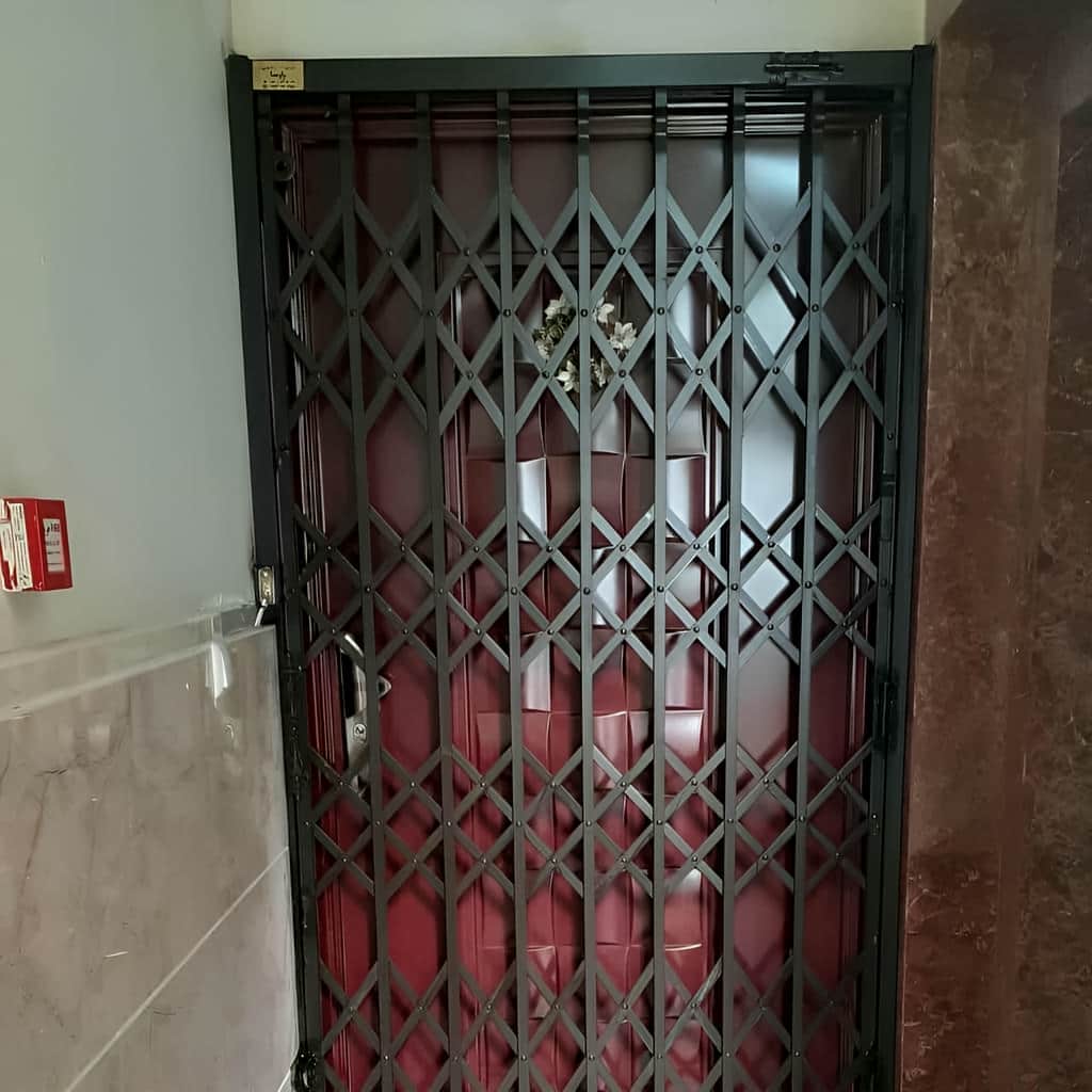 نرده آکاردئونی پشت درب آپارتمان